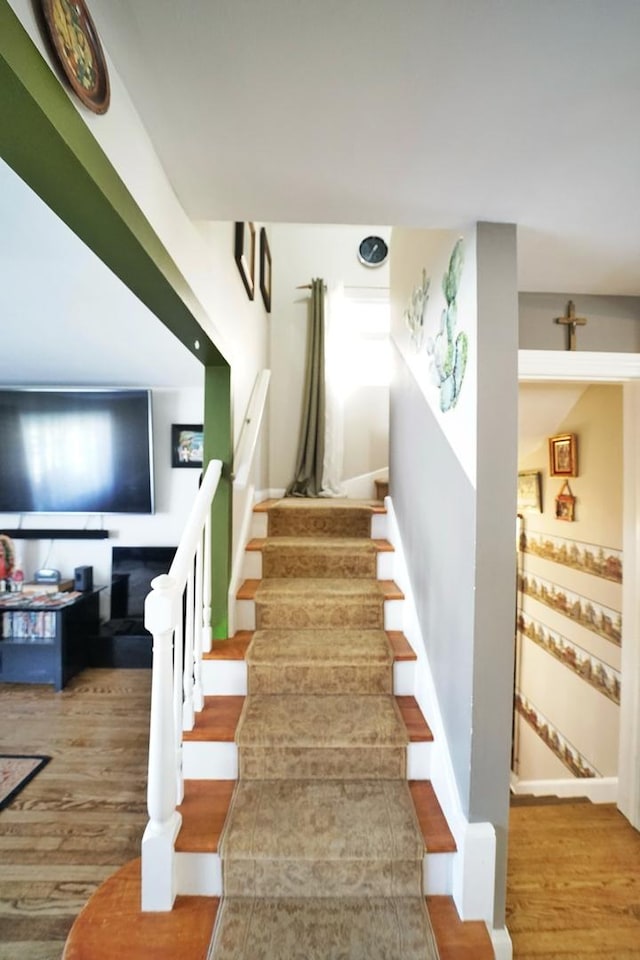 stairway with baseboards and wood finished floors