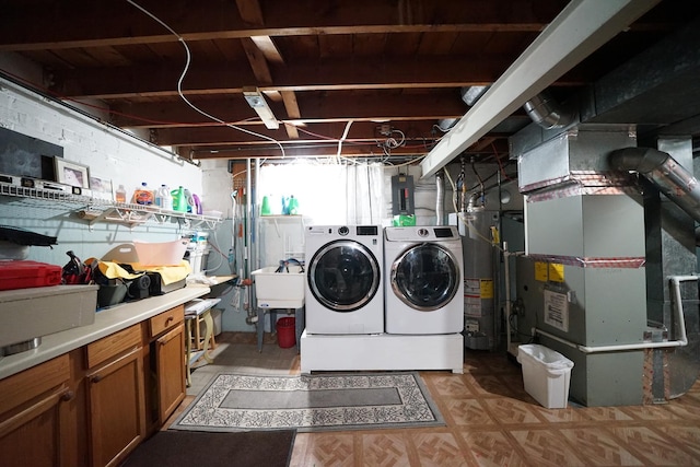 laundry area featuring gas water heater, laundry area, separate washer and dryer, a sink, and heating unit