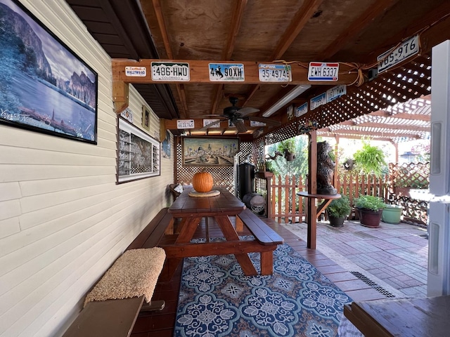 game room with wood ceiling, a ceiling fan, and wooden walls