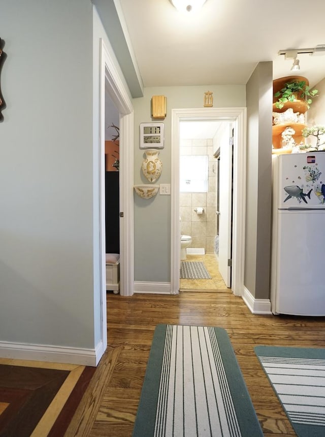 hallway featuring baseboards and wood finished floors