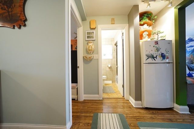 hallway with baseboards and wood finished floors