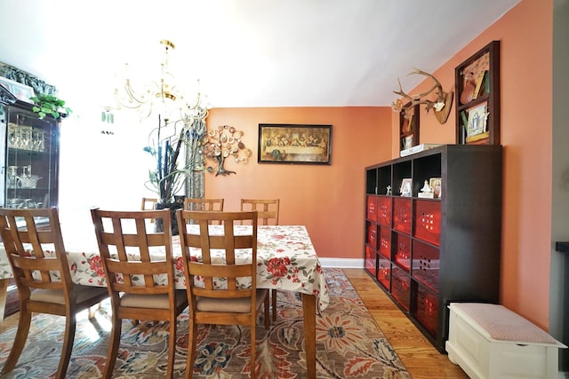 dining room featuring an inviting chandelier, baseboards, and wood finished floors