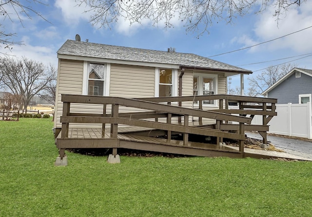 back of house with a wooden deck, fence, and a yard