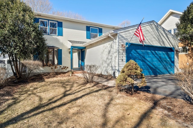 traditional-style home featuring an attached garage and aphalt driveway