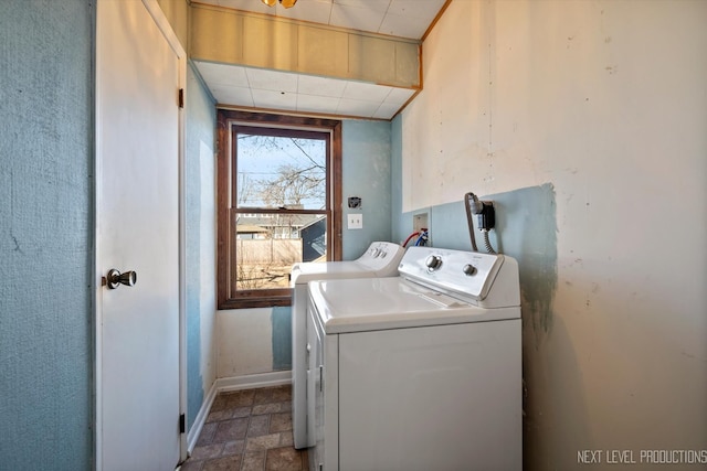 laundry area with laundry area, stone finish floor, baseboards, and separate washer and dryer