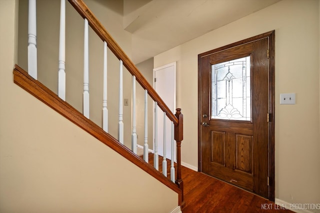 foyer entrance featuring stairs, baseboards, and wood finished floors