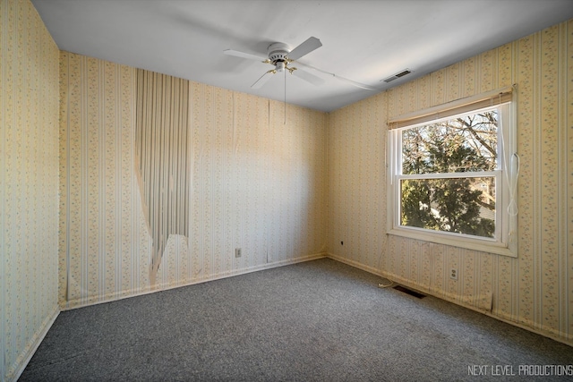 unfurnished room with carpet floors, visible vents, and wallpapered walls