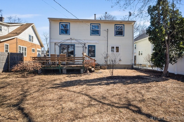 back of house featuring a deck and fence