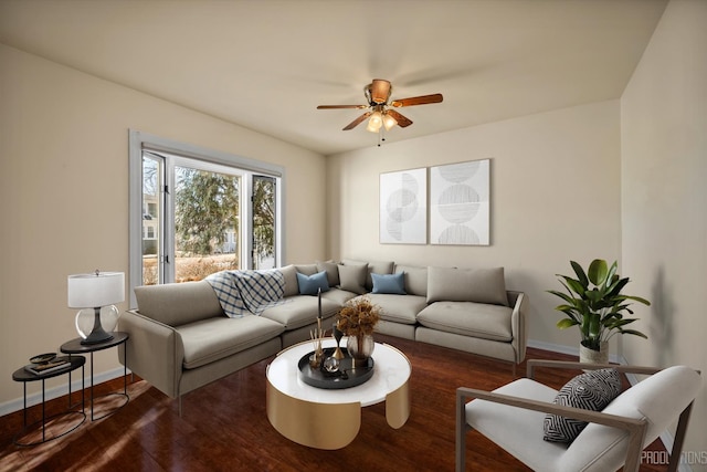 living area featuring wood finished floors, a ceiling fan, and baseboards