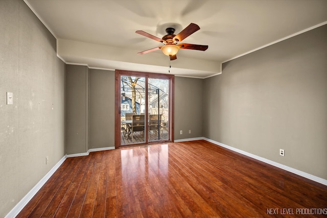 empty room featuring ornamental molding, ceiling fan, baseboards, and wood finished floors