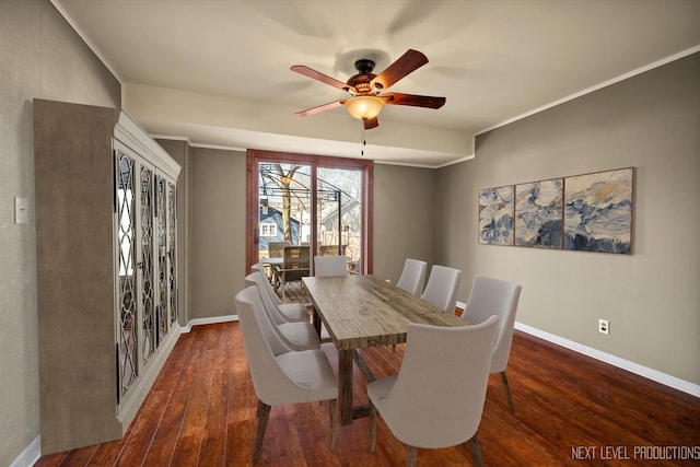 dining room featuring a ceiling fan, crown molding, baseboards, and wood finished floors