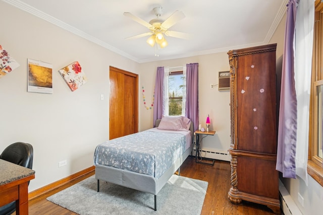 bedroom with baseboards, crown molding, a baseboard heating unit, and wood finished floors