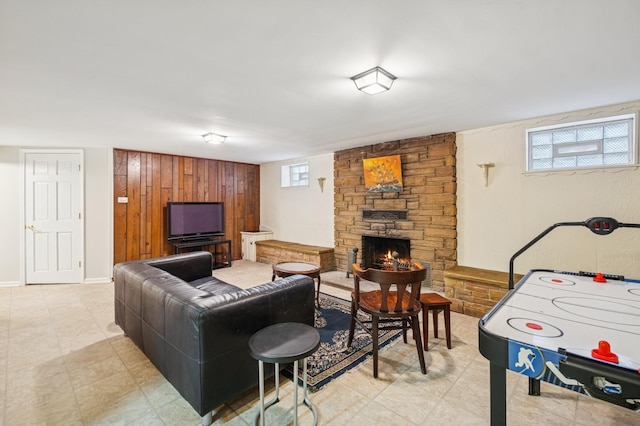 living area featuring a stone fireplace and baseboards