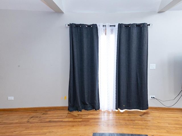 empty room featuring baseboards and wood finished floors