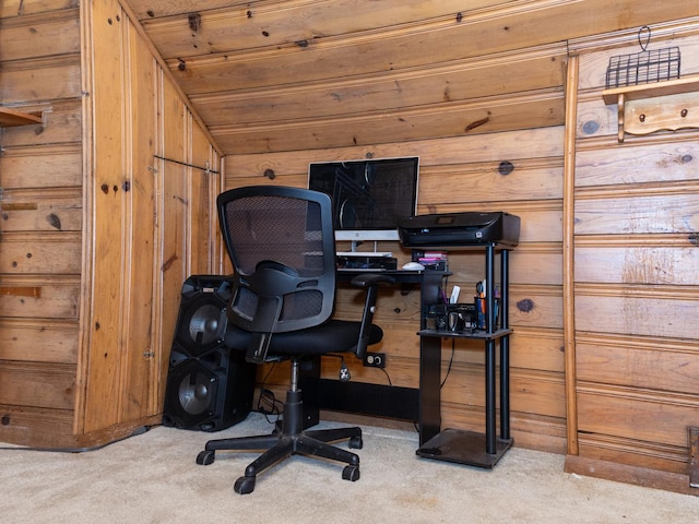 carpeted office space featuring lofted ceiling and wood walls