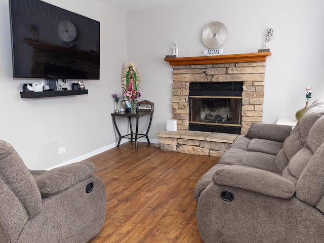 living area with a fireplace, wood finished floors, and baseboards