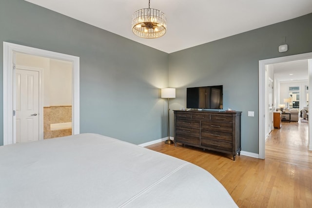 bedroom with a chandelier, wood finished floors, and baseboards