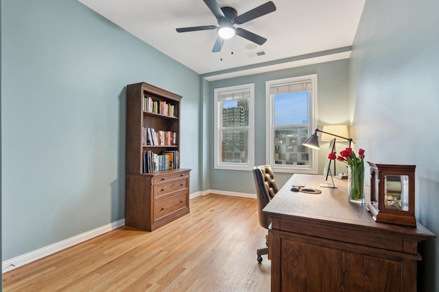 office featuring baseboards, visible vents, a ceiling fan, and light wood-style floors