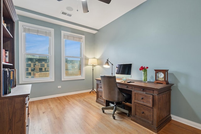 office space featuring ceiling fan, light wood-style flooring, visible vents, and baseboards