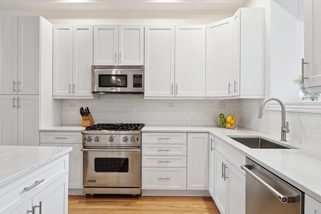 kitchen featuring appliances with stainless steel finishes, a sink, and white cabinetry