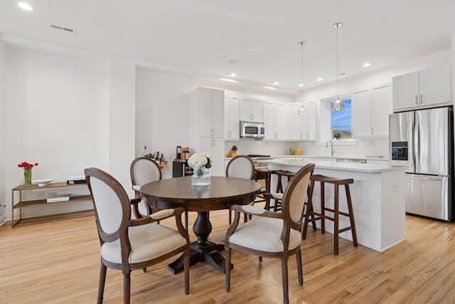 dining space featuring recessed lighting, visible vents, and light wood finished floors