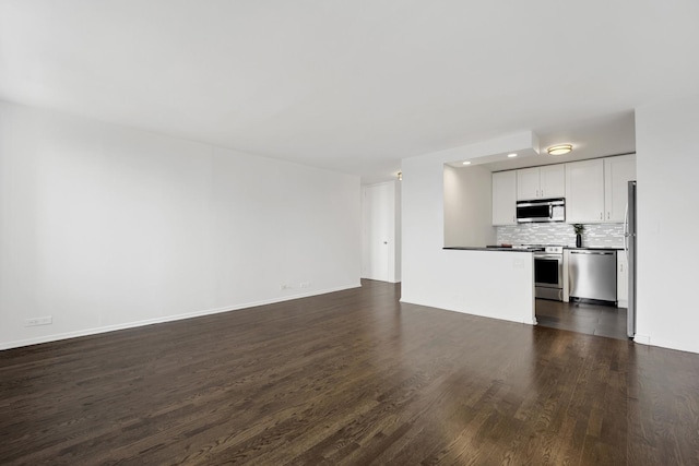 unfurnished living room with recessed lighting, dark wood finished floors, and baseboards