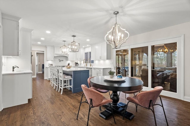 dining area with baseboards, dark wood-style flooring, recessed lighting, and a notable chandelier