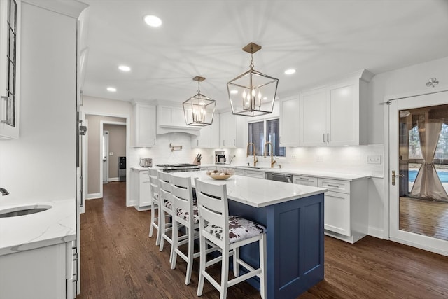 kitchen featuring dark wood-type flooring, backsplash, a sink, and white cabinetry