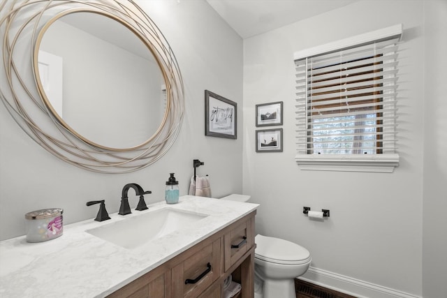 bathroom with baseboards, vanity, and toilet