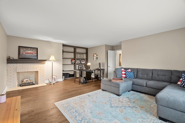 living room with a fireplace, wood finished floors, and baseboards