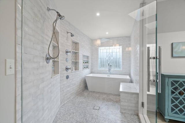 full bathroom featuring recessed lighting, a freestanding bath, a tile shower, and tile patterned floors