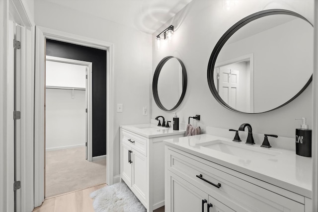 bathroom with two vanities, a sink, and baseboards