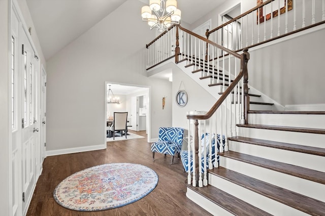 foyer with high vaulted ceiling, wood finished floors, baseboards, stairs, and an inviting chandelier