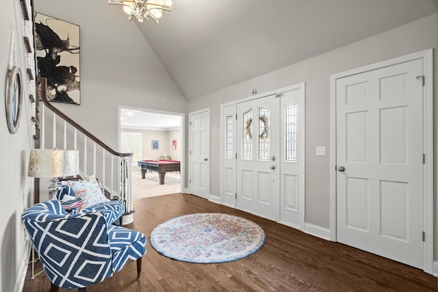 foyer entrance featuring baseboards, a chandelier, wood finished floors, pool table, and high vaulted ceiling