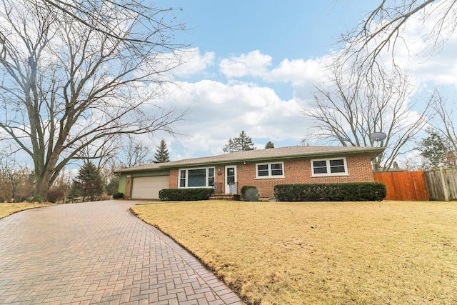 ranch-style home featuring a garage, brick siding, fence, decorative driveway, and a front yard