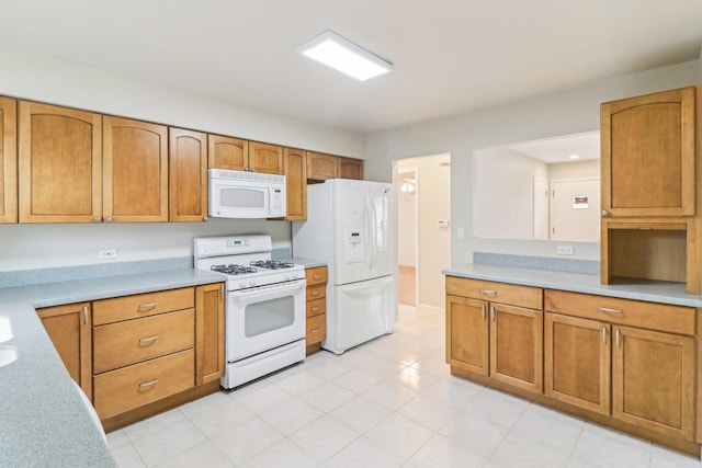 kitchen with white appliances, brown cabinetry, and light countertops