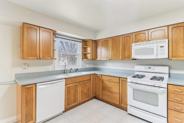 kitchen featuring brown cabinetry, white appliances, light countertops, and a sink