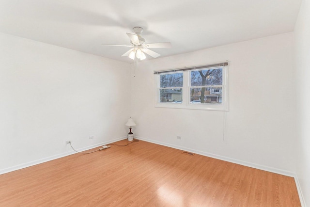 unfurnished room featuring ceiling fan, light wood-type flooring, and baseboards