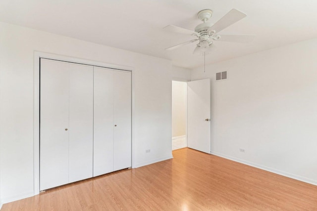 unfurnished bedroom featuring a ceiling fan, baseboards, visible vents, light wood-style floors, and a closet