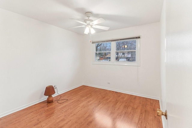 empty room with baseboards, ceiling fan, visible vents, and light wood finished floors