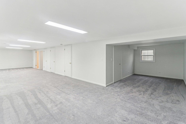 basement featuring baseboards and carpet flooring