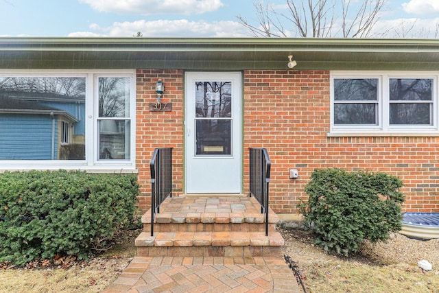 entrance to property featuring brick siding