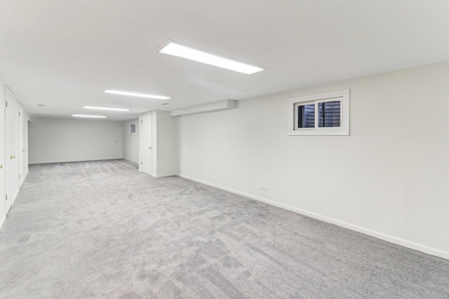 finished basement with light colored carpet and baseboards