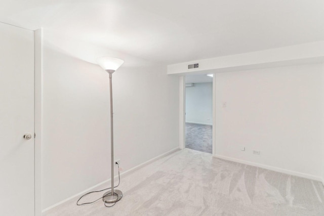 unfurnished room with carpet floors, visible vents, and baseboards