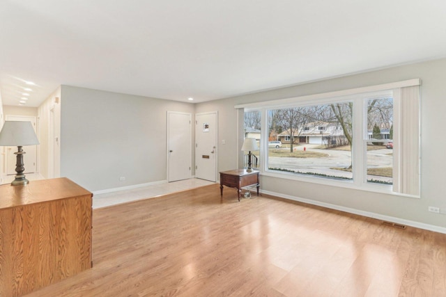 interior space featuring light wood-style flooring, visible vents, and baseboards