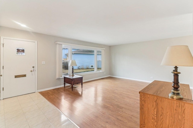 foyer entrance featuring light wood-style flooring and baseboards