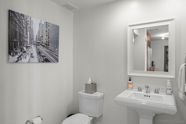 bathroom with visible vents, a sink, and toilet