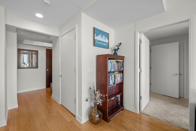 hall with light wood-style floors and baseboards