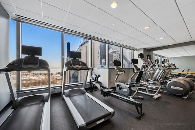 exercise room featuring baseboards, a drop ceiling, and recessed lighting