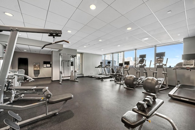 exercise room with baseboards, a drop ceiling, and recessed lighting